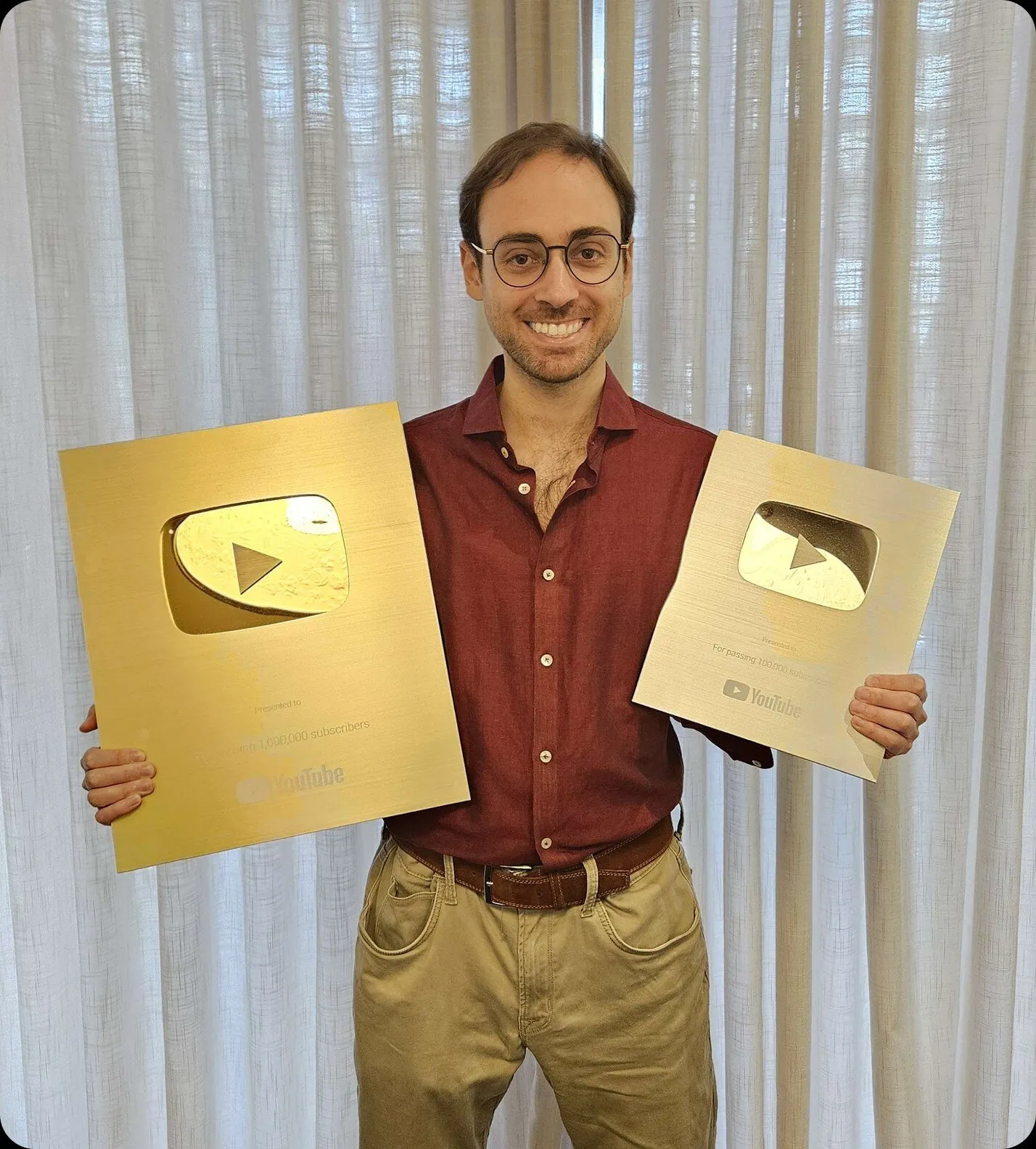 A member of our team holding YouTube Gold and Silver Creator Awards